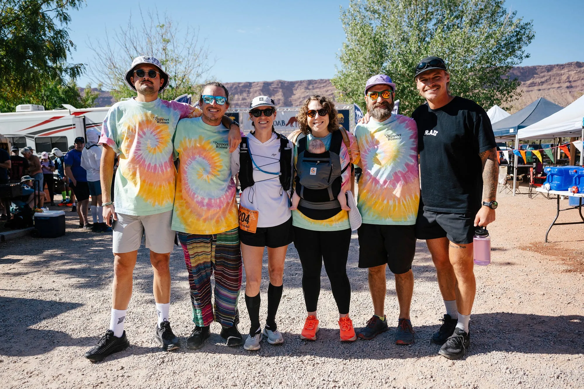 Lucy's crew at the Moab 240 in matching tie-dye shirts, lined up in the sun.