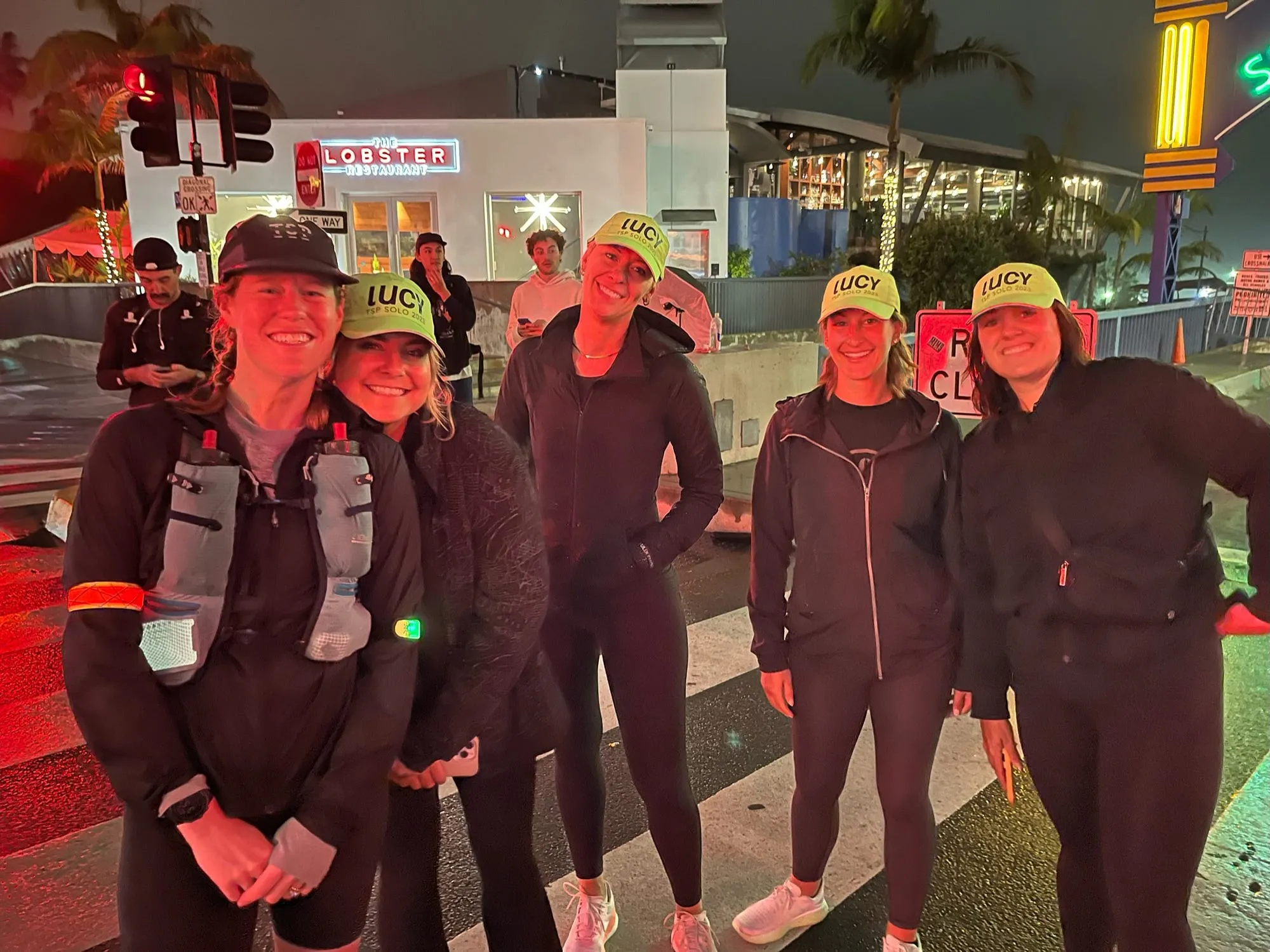 Lucy and her crew at night outside a lit storefront during The Speed Project.